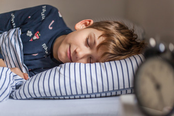 Cute boy sleeping in a bed.