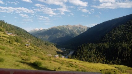 a view of village and mountains in a valley