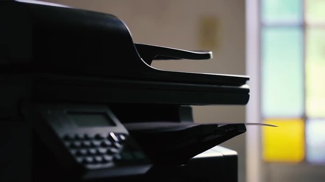 Office Printer Printing A White Sheet of Paper. Close-Up.