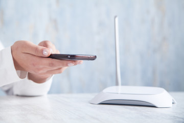 Internet router in the desk. Girl using smartphone