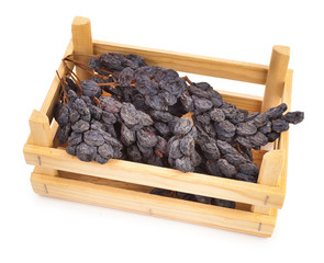 Cluster of raisins in the wooden box isolated on a white background.