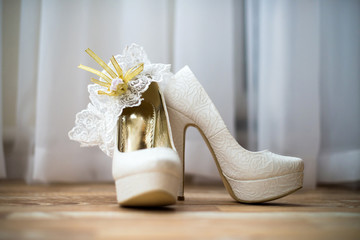 Bride's shoes and garter on the wooden floor