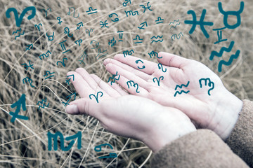 Hands release blue astrological symbols