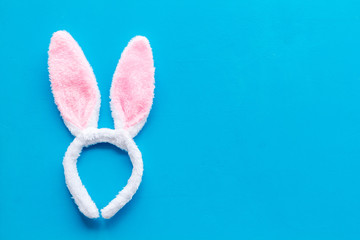 Easter bunny concept. Toy rabbit's ears for head on blue background top-down copy space