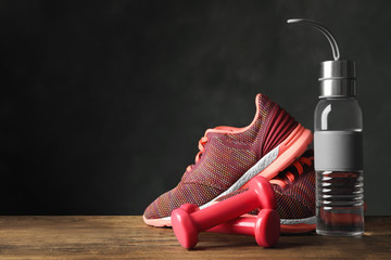 Gym equipment and accessories on floor against dark background. Space for text