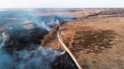 Forest and field fire. Dry grass burns, natural disaster. Aerial view.