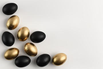 Easter golden and black eggs frame on white background. Textured. Isolated eggs. Copy space, top view, flat lay.  Happy Easter luxury concept