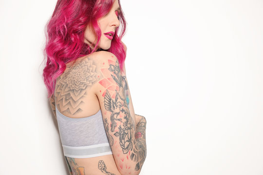 Beautiful woman with tattoos on body against white background. Space for text