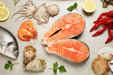 Fresh fish and seafood on light grey table, flat lay