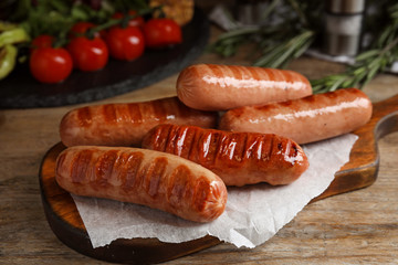 Delicious grilled sausages served on wooden table