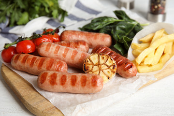 Delicious grilled sausages served on white table