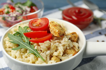 Delicious chicken risotto served in bowl, closeup