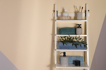 Shelving unit with toiletries near light wall indoors, space for text. Bathroom interior element