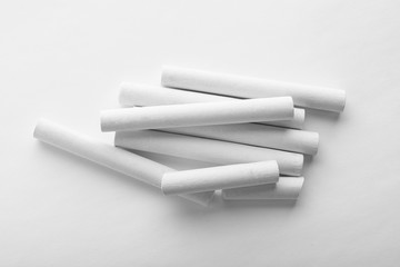 Pieces of chalk on white background, top view