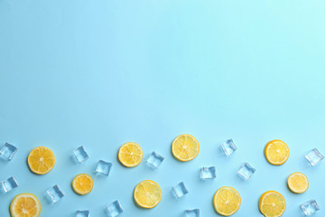 Lemonade layout with juicy lemon slices and ice cubes on light blue background, top view. Space for text