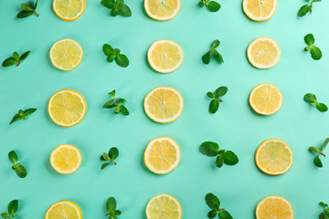 Lemonade layout with juicy lemon slices and mint on turquoise background, top view