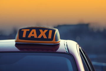 Taxi car with yellow roof sign outdoors, closeup