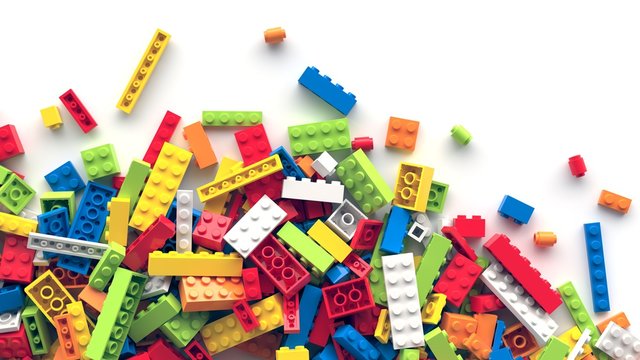 Colorful toy bricks scattered on white background