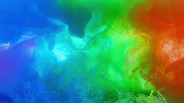 A beautiful mixture of acrylic ink in water. Ink streams of rainbow colors form abstract clouds when mixed. Acrylic clouds on a white background. Slow motion