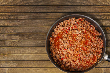 Pan of sauce bolognese on wood background