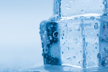 Ice cubes macro square with drops water clean on blue background