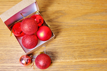 The red ball that was hit by light and the green leaves on the wooden table. valentine and chistmas concept