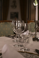 A glass on the table for wine. Interior of a classic restaurant in an old castle. Traveling in Europe. Served tables and antiquity.