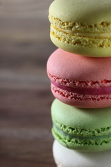 colored French cakes on a textured wooden background