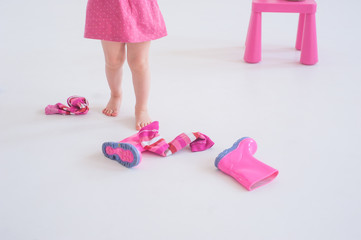 Bare feet of a little girl in a pink dress