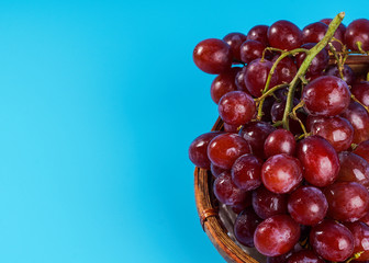 Close up on fresh grape in an old buskets on blue background with copyspace.