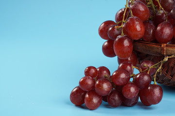 Close up on fresh grape in an old buskets on blue background with copyspace.