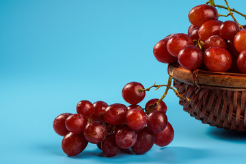 Fresh grape in an old buskets on blue background with copyspace. Selective focus