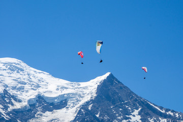 Paragliders looking for thermals amongst the snow caps of the Monte Blanc Massif, Chamonix, France