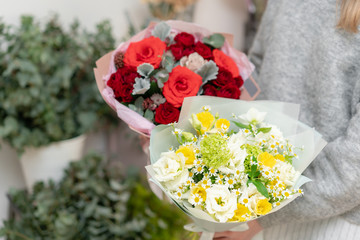 Two Beautiful bouquets in womans hands. the work of the florist at a flower shop. Delivery fresh cut flower. European floral shop.