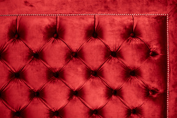 Red luxury velour quilted sofa upholstery with buttons, elegant home decor texture and background