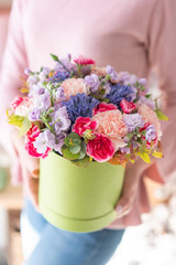 European floral shop. Floral bunch in round box. Bouquet of beautiful Mixed flowers in woman hand. Excellent garden flowers in the arrangement , the work of a professional florist.