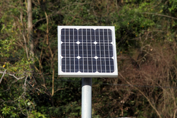 Solar battery for generating electric energy against the background of green plants.