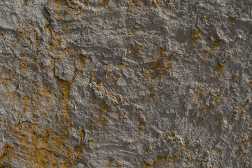 Grey brown texture of the stone wall. A gray wall with rusty streaks on it.