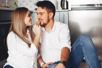 Loving couple have fun at home. Pretty blonde in a white blouse.