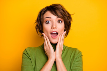OMG. Closeup photo of funny lady listen positive good news open mouth arms on cheeks wear casual green turtleneck warm sweater isolated yellow color background - obrazy, fototapety, plakaty