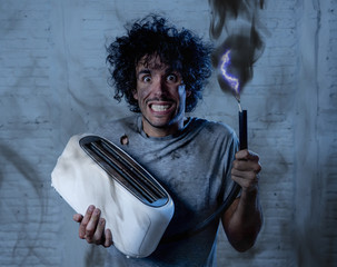 Funny man after suffering an electric shock fixing a toaster. Domestic accidents concept.