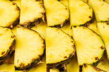 Pineapple juicy yellow slices background. Top view.