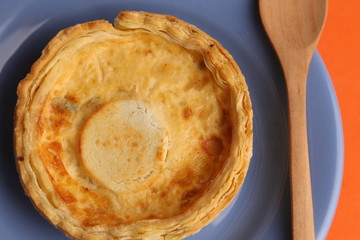 Delicious three cheese quiche in colored background