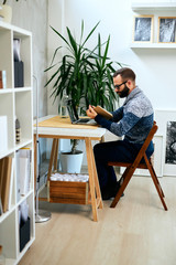 Attractive freelancer sitting in modern office reading.	