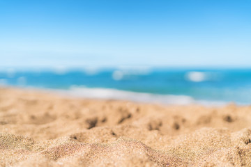 Fototapeta na wymiar Summer beach background blurry blue ocean on white sand texture. Tropical Caribbean travel vacation copy space for advert.