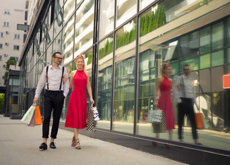 Happy couple walking while shopping in the city.