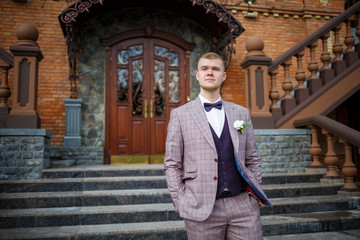 Groom in a beautiful plaid suit and bow-tie