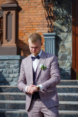 Groom in a beautiful plaid suit and bow-tie