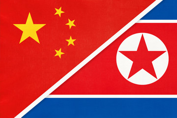 People's Republic of China or PRC vs North Korea national flag from textile. Relationship between two asian countries.