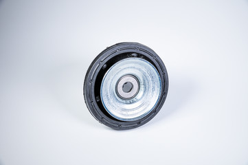 New thrust bearing of front suspension strut of a car on a gray background. The concept of new spare parts and replacement parts in service centers